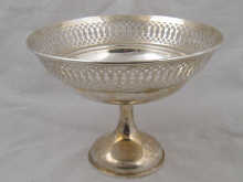 A silver cake basket on pedestal