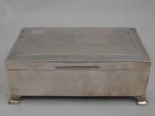 A silver cigarette box on feet with