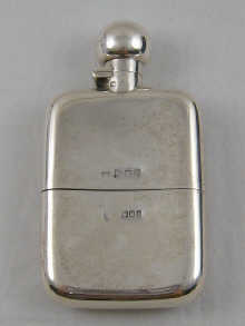 A silver hip flask with cup