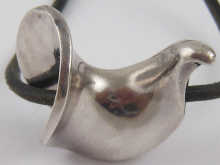 A silver pendant on black leather