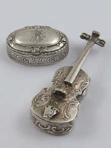 A silver pill box in the form of