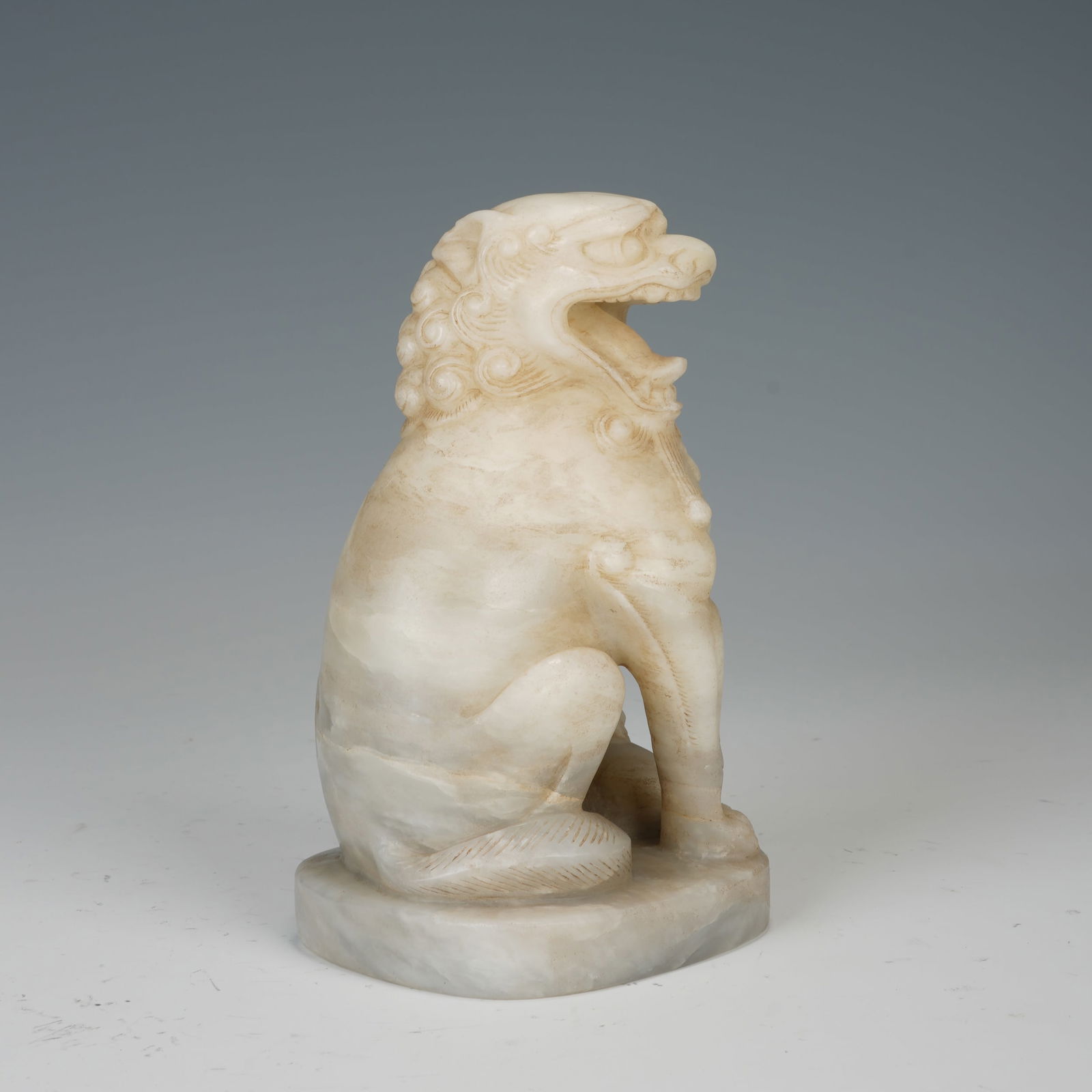 A STONE - CARVED SQUATTING LION