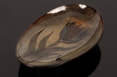 A studio pottery oval dish on three