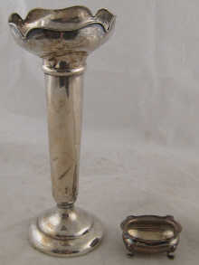 A tall silver vase loaded ht.