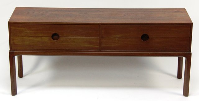 A teak chest of four drawers on