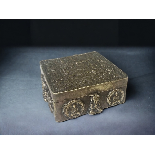 A TIBETAN EMBOSSED METAL TRINKET