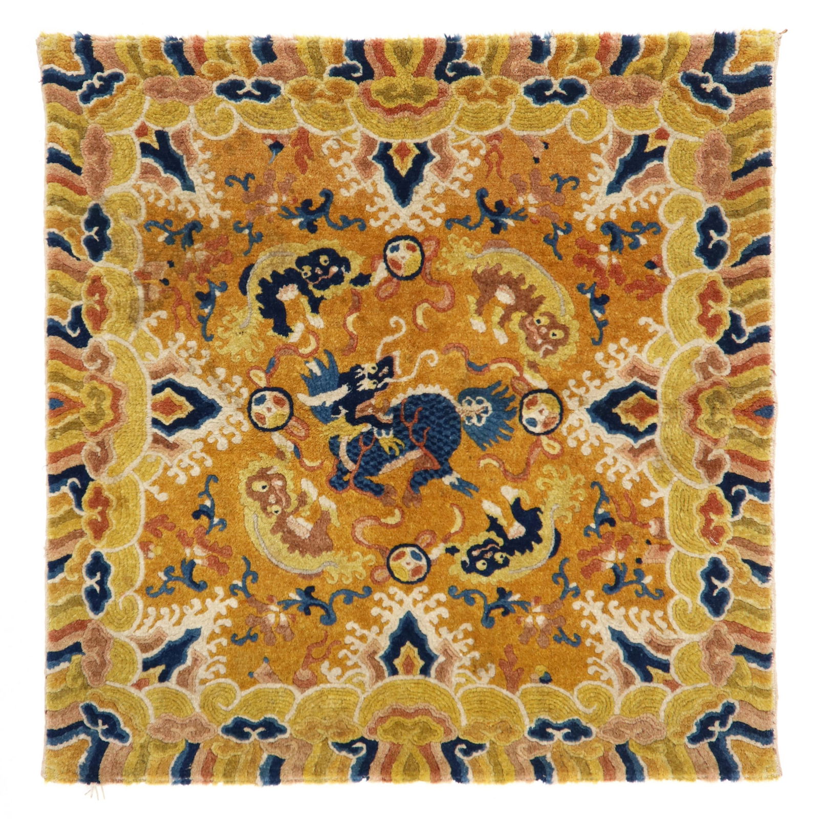 A TIBETAN YELLOW GROUND RUG WITH 