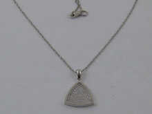 A triangular diamond pendant set in