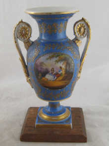 A two handled vase on a square foot