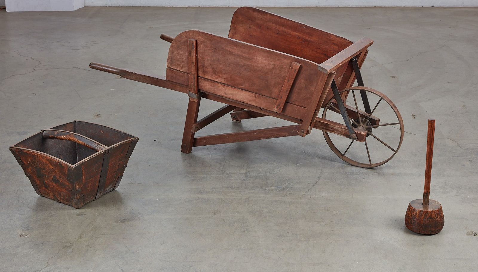A WHEELBARROW WITH A WOOD BUCKET