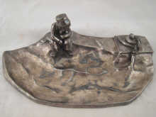 A white metal ink stand designed as