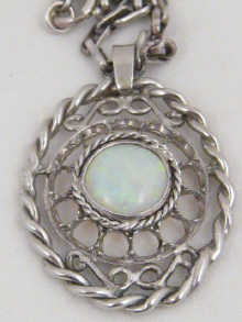 A white metal (tests gold) oval