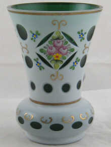 A white overlay on green glass vase