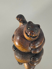 A WOOD NETSUKE OF A TANUKI NO
