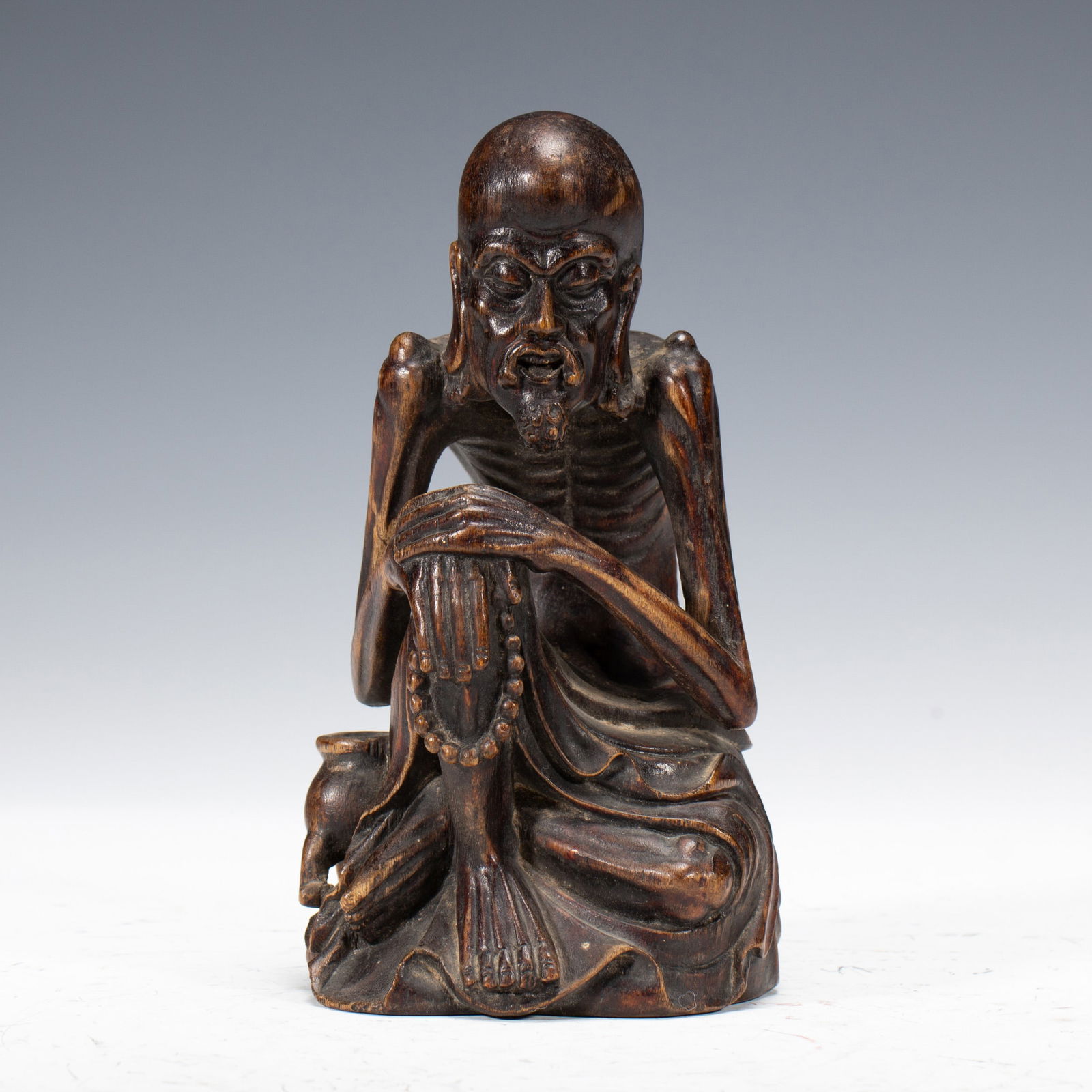 A WOODEN - CARVED STATUE OF AN