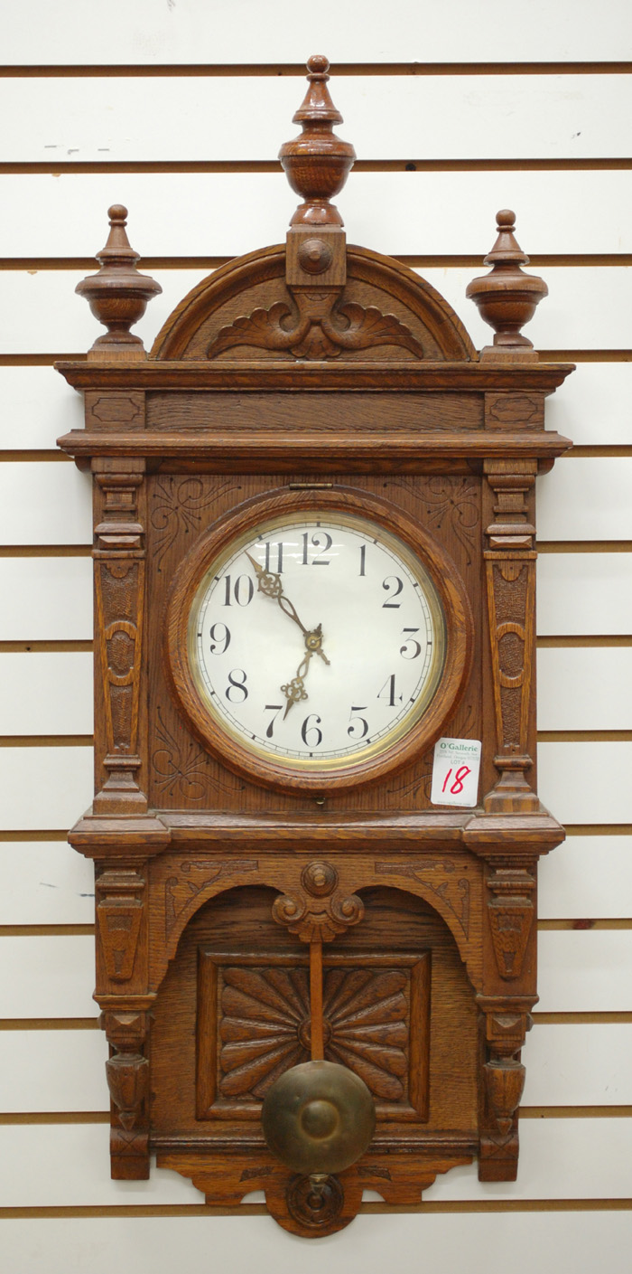 AN AMERICAN OAK CASED WALL CLOCK