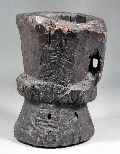 An ancient wooden mortar of waisted