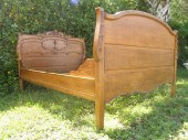 An antique carved oak bedframe