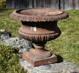 An antique cast iron urn, with a