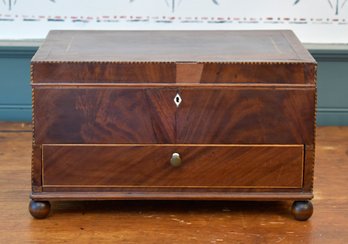 An antique hinged lift top mahogany