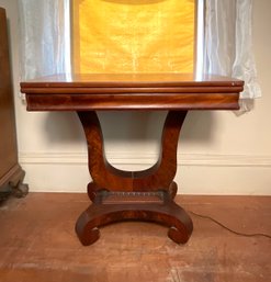 An antique mahogany card table with