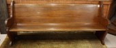 AN ANTIQUE OAK CHURCH BENCH, A