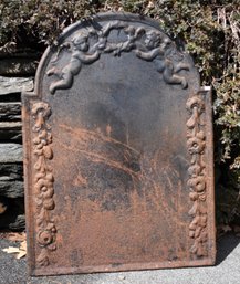 An atique cast iron fireback with