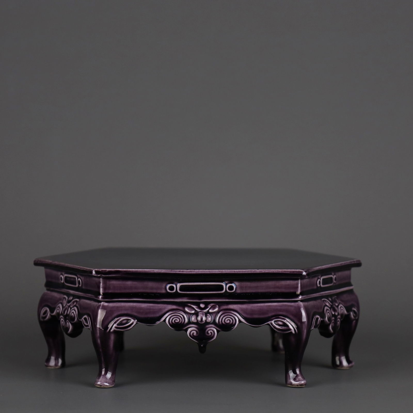 AN AUBERGINE-GLAZED CARVED