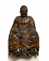AN EAST ASIAN CARVED WOOD FIGU