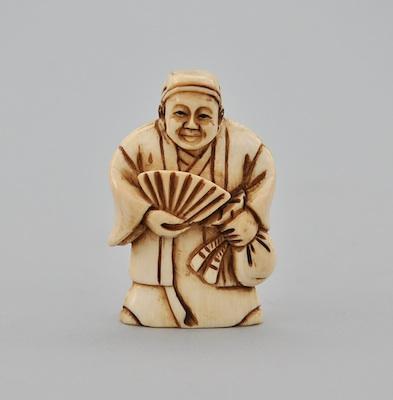 An Ivory Netsuke of A Man Holding a