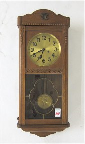 AN OAK BOX-CASE WALL CLOCK Gus
