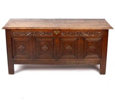 An oak chest with carved panel
