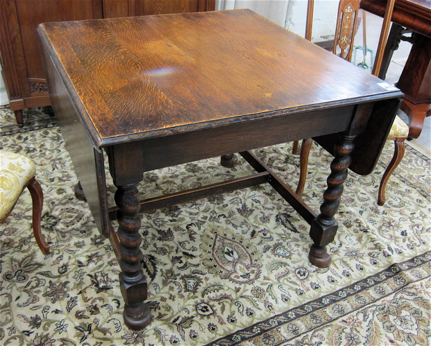 AN OAK DROP-LEAF DINING TABLE