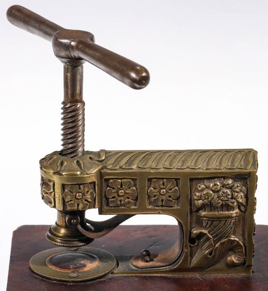 AN ORNATE BRASS PAPER EMBOSSING