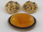 An oval amber brooch set in wh