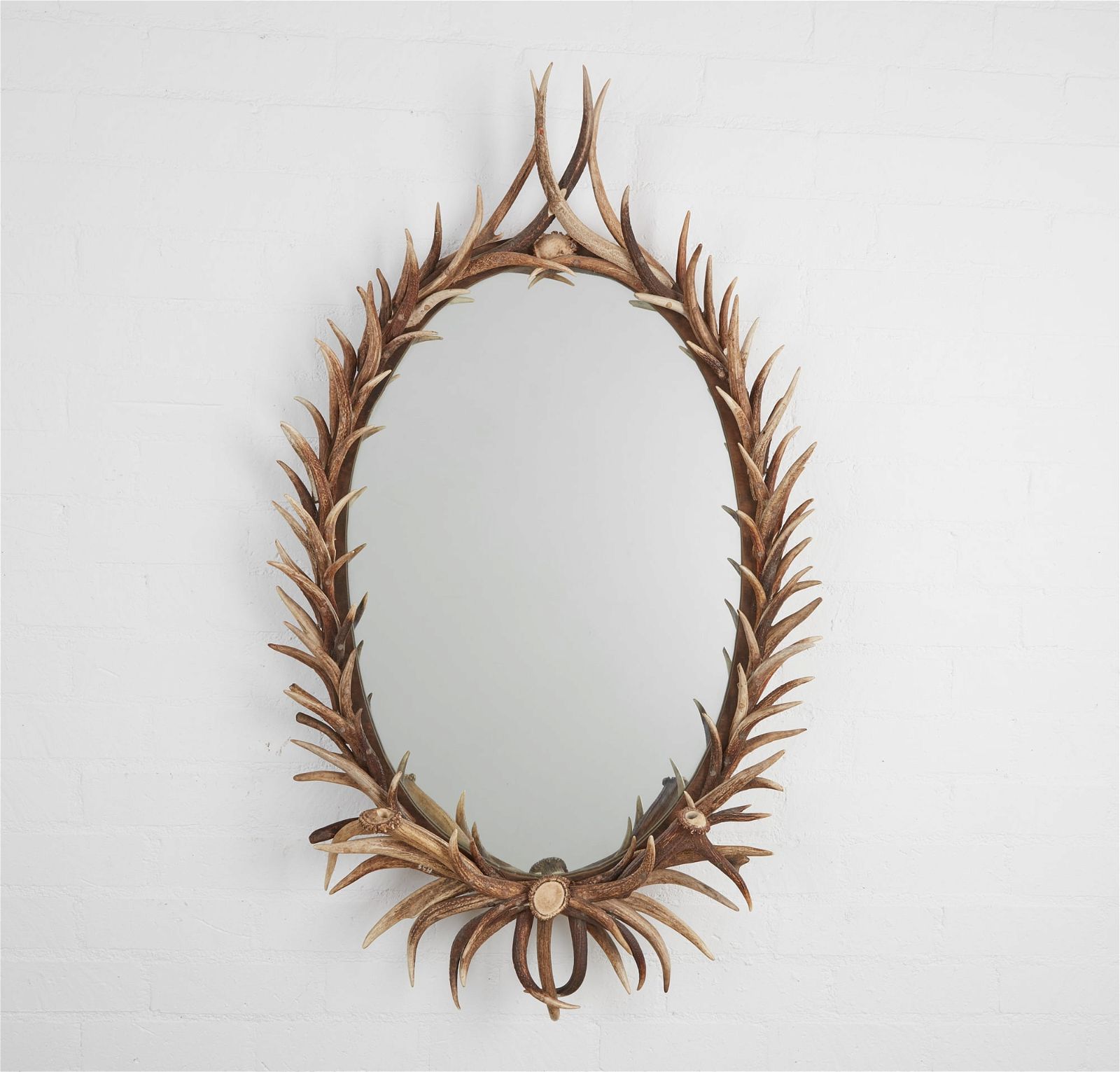 AN OVAL ANTLER FRAME MIRRORAn