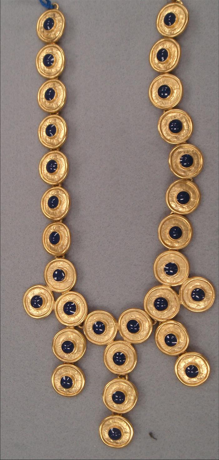 Bib featuring goldtone discs with