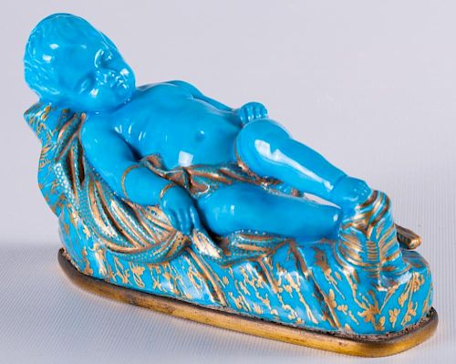 BLUE CHILD FIGURINE REPOSED ON