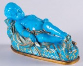 BLUE CHILD FIGURINE REPOSED ON