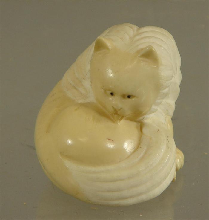 Carved ivory curled cat figure,