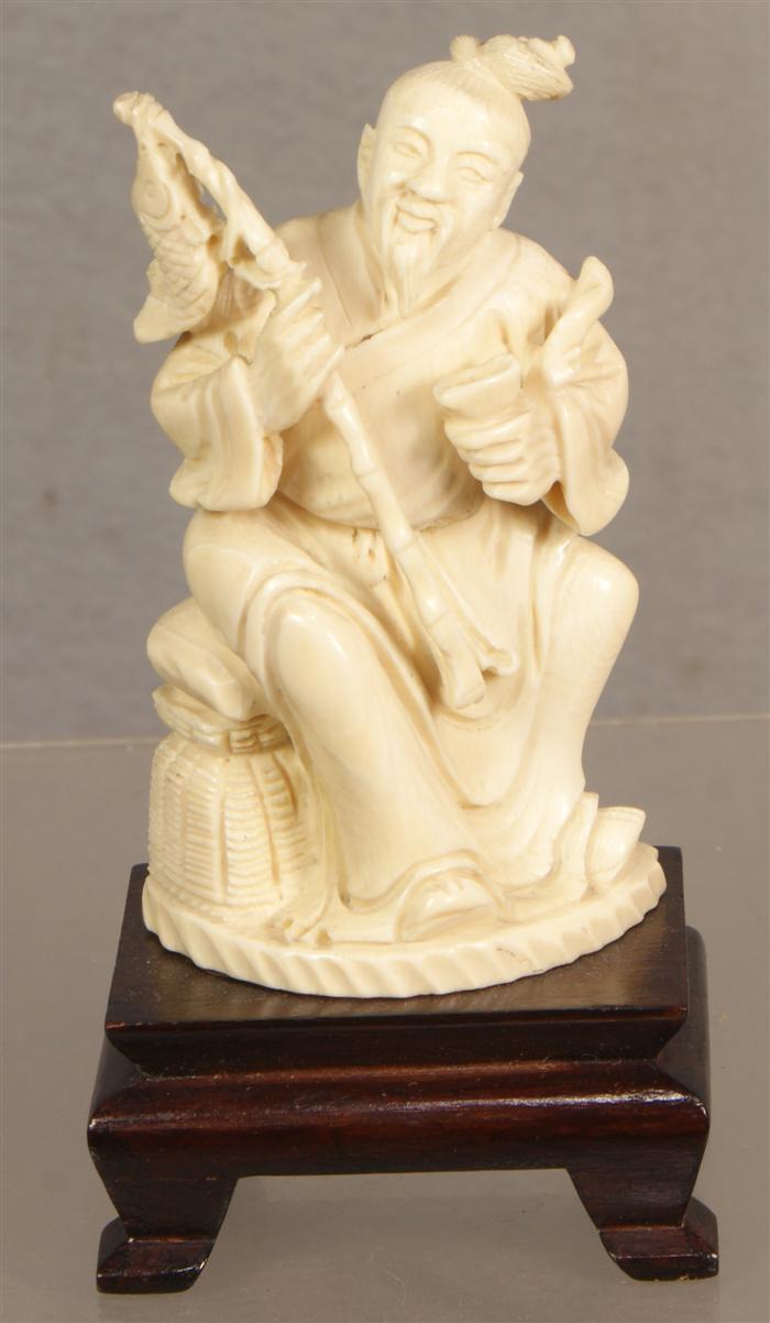 Carved ivory fisherman, measures 4"