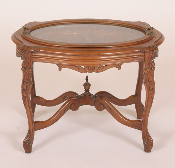 Carved walnut oval table with glass