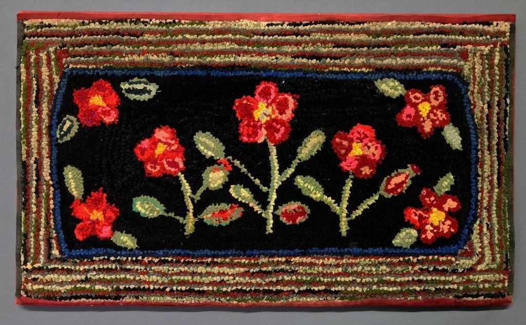 Colorful hooked rug of red flowers,