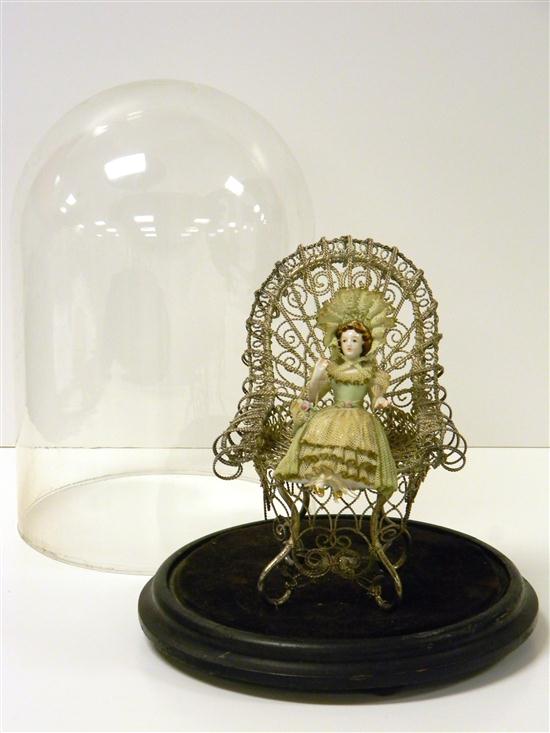 Dome-encased doll in elaborate