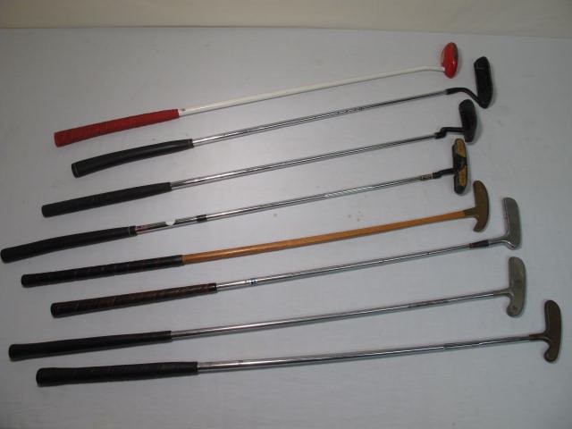 Eight assorted putter golf clubs.