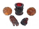 FIVE CARVED AMBER-TYPE PIECES,