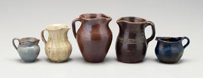 Five pottery pitchers: one with
