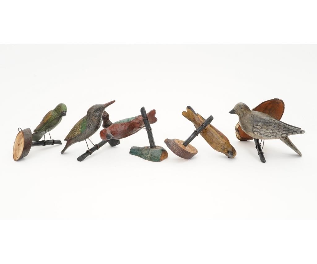 Five wood carved birds perched on