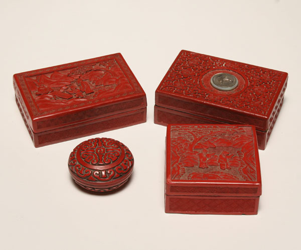 Four carved cinnabar boxes; all