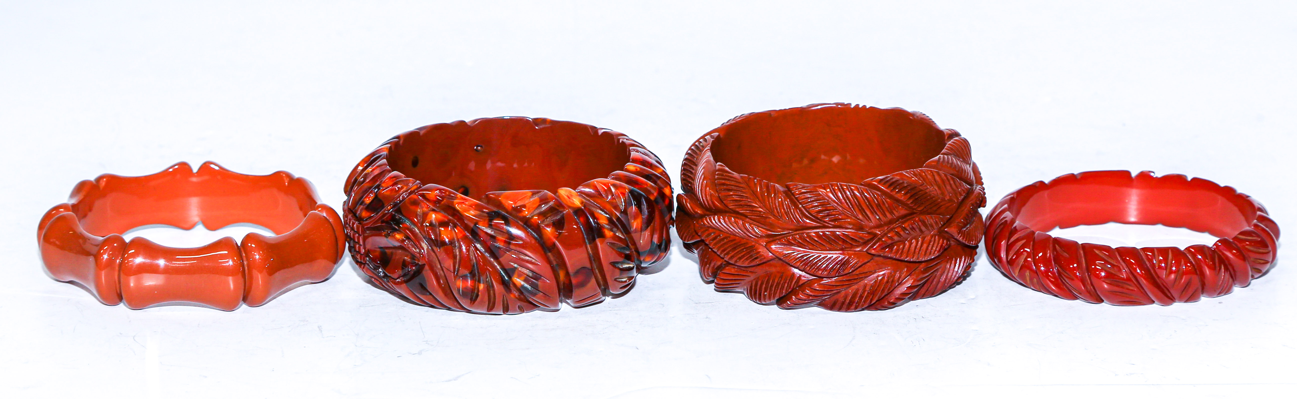 FOUR CARVED ORANGE & RED BAKELITE